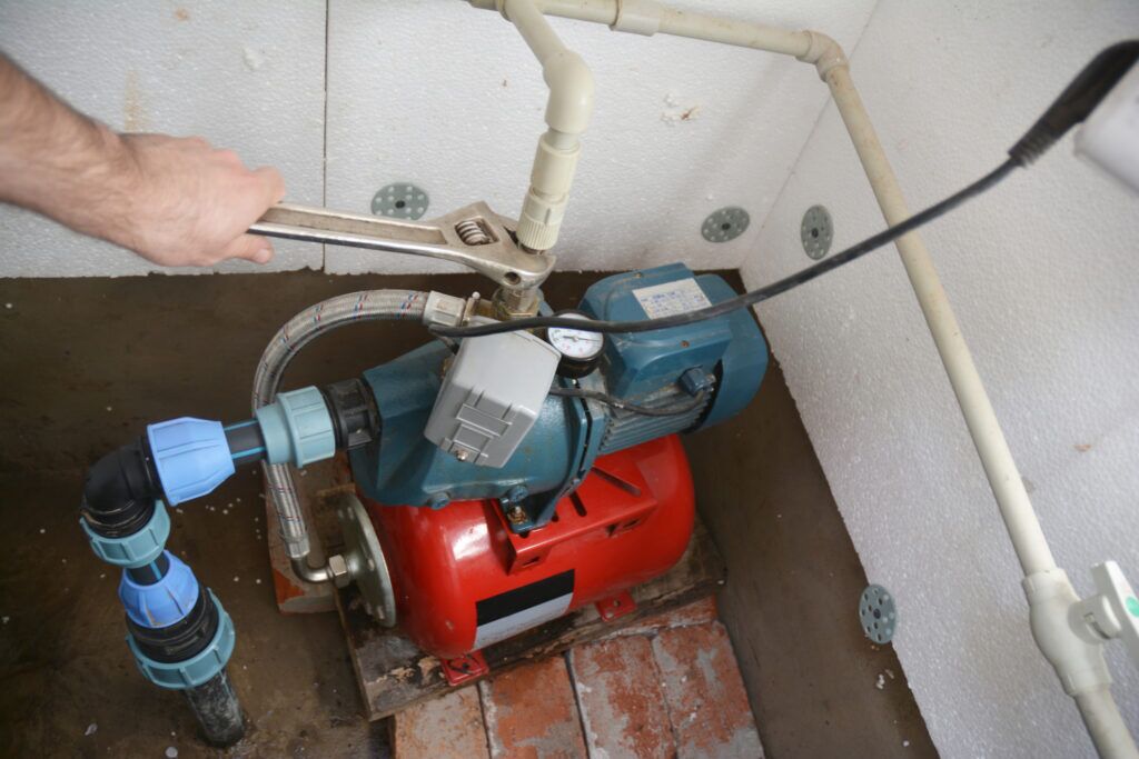 Contractor installing and repairing water well pumping station. 